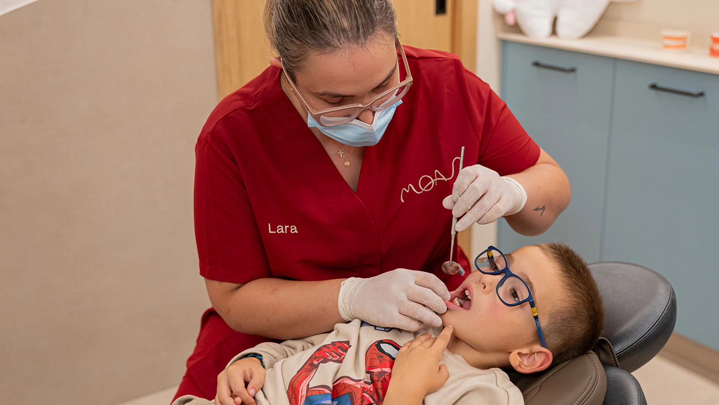 Odontopediatra realizando una exploración oral a paciente pediátrico