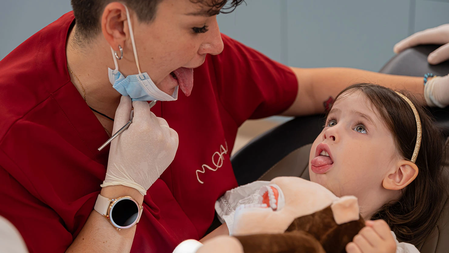 Dentista infantil realizando ejercicios con la lengua para revisar hábitos orales